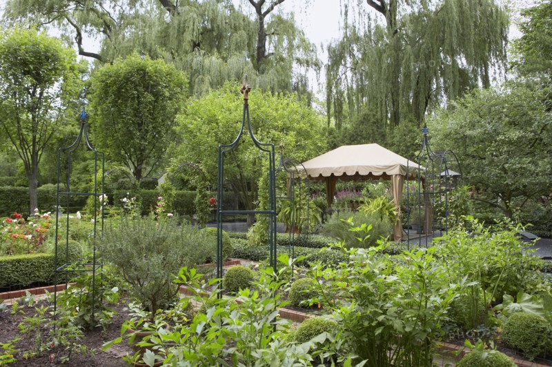 Shaped hedges surround flower beds in controlled rectangles with paths leading in between