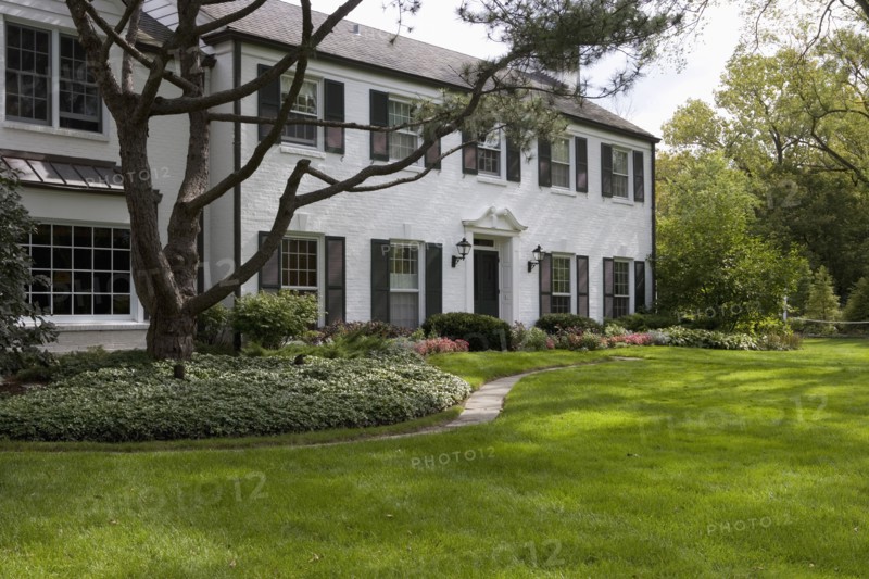 White brick traditional colonial home with black shutters