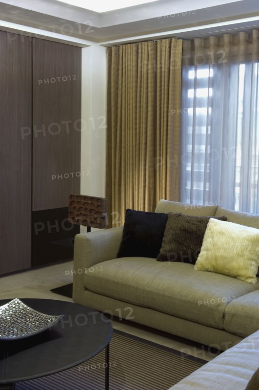 Detail contemporary sofa in front of window with drapes
