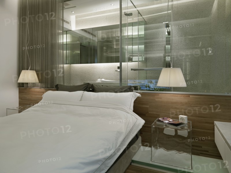 Modern bedroom with glass wall to bathroom
