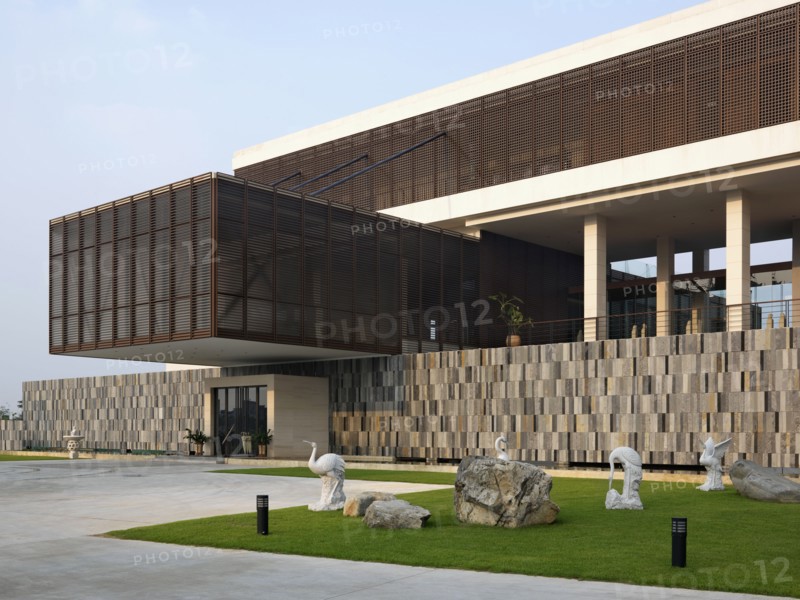 Crane statues on lawn outside modern building
