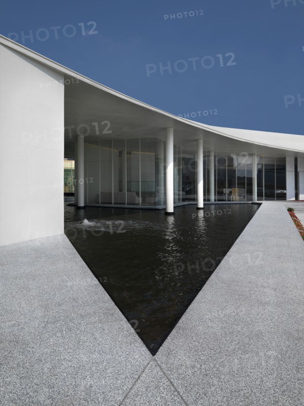 Triangular shaped pool outside modern building