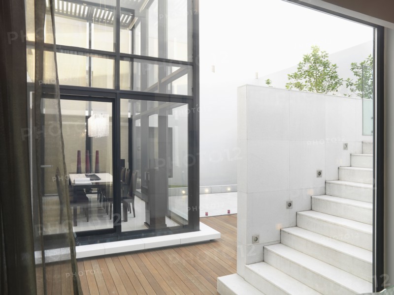 White staircase leading to deck and glass dining room