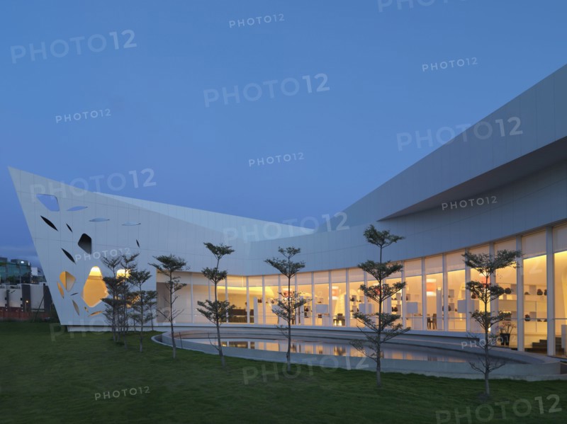 Row of trees and reflecting pool out front of modern building