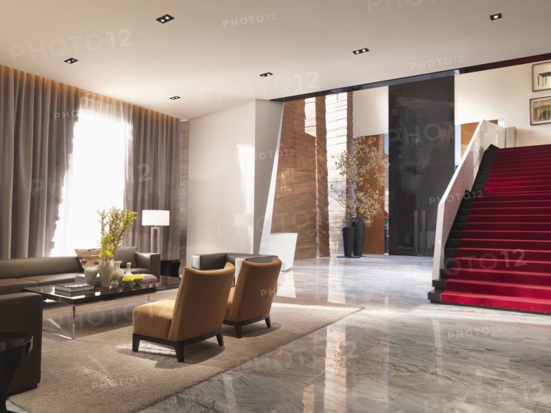 Sitting area and grand red staircase in modern interior
