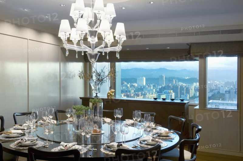 Large circular dining table in dining room with city view