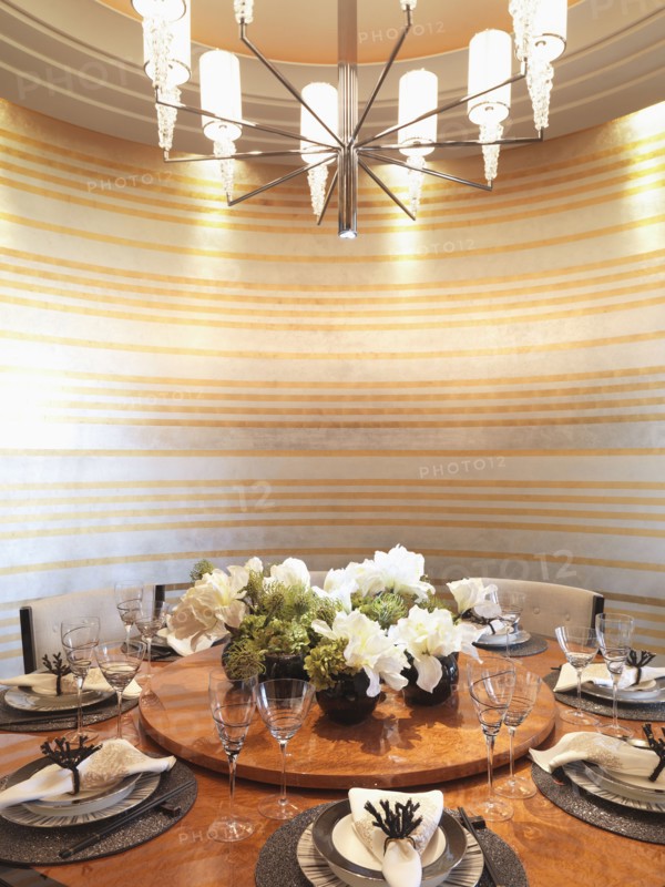 Circular dining table and striped wall paper in modern dining room