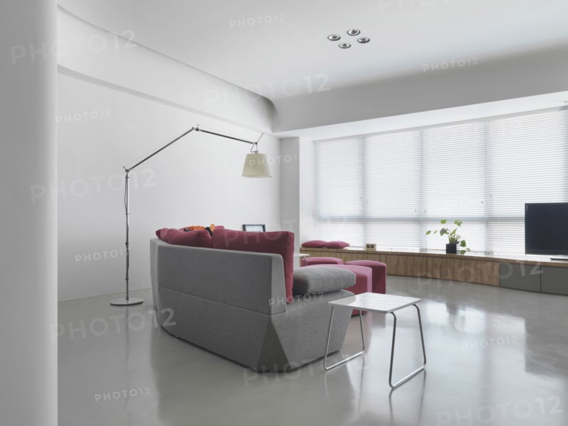 Gray sofa in living room with several windows