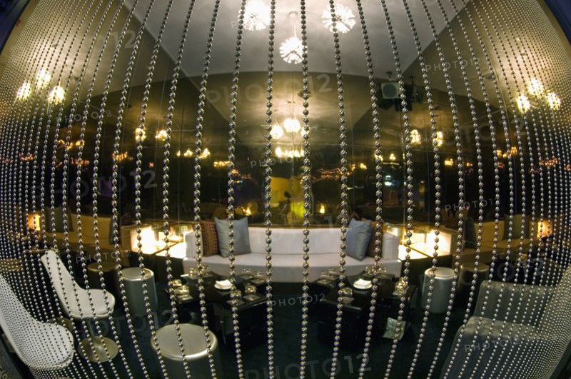Fisheye view of lounge area behind beaded curtain in nightclub