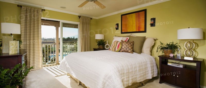 Green master bedroom with sliding glass doors