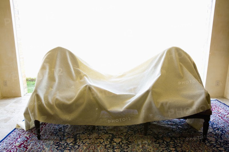 Two chairs covered in a white sheet