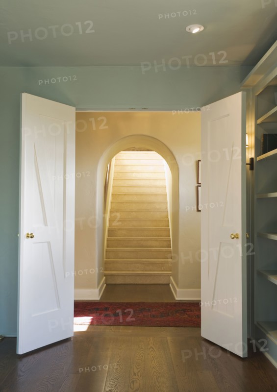 Open double doors leading to an upward staircase