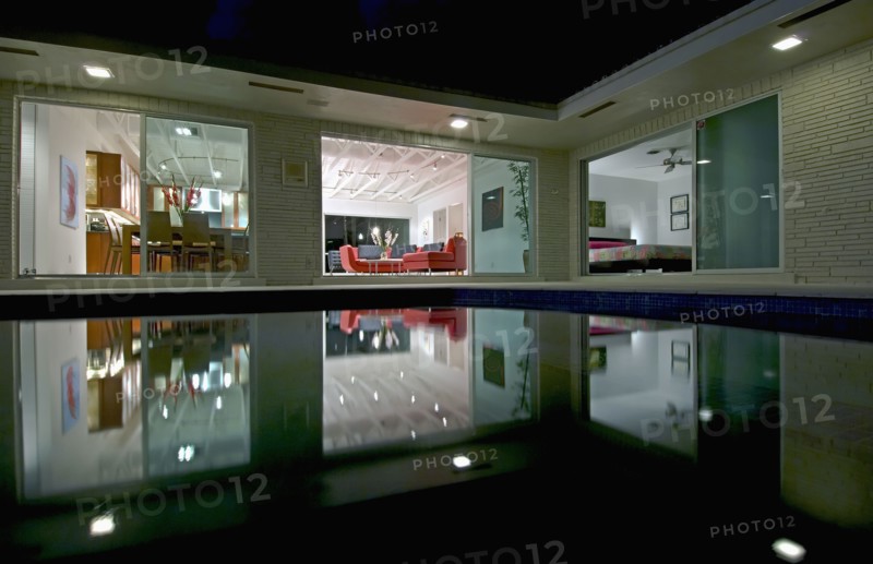 Night view in towards living room of home across pool