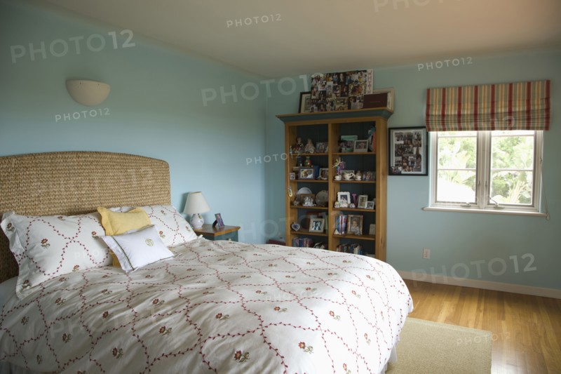 Bed with floral print comforter in blue bedroom
