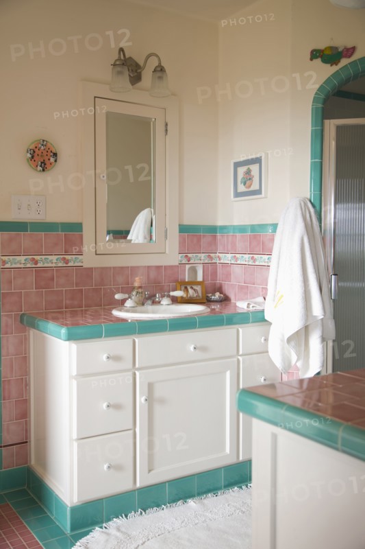 Bathroom sink and counter in pink and teal tiled bathroom