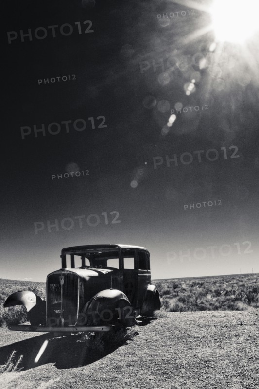 Vintage car missing tires in remote field