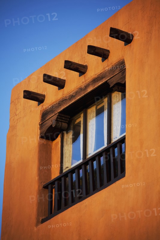 Low angle view of posts and window in adobe house