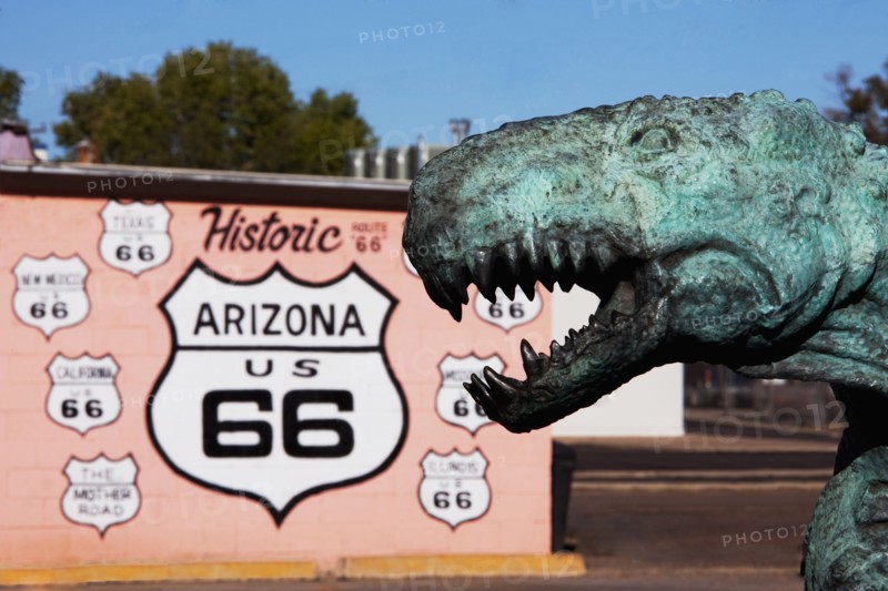 Close up of dinosaur statue by Historic Route 66 sign