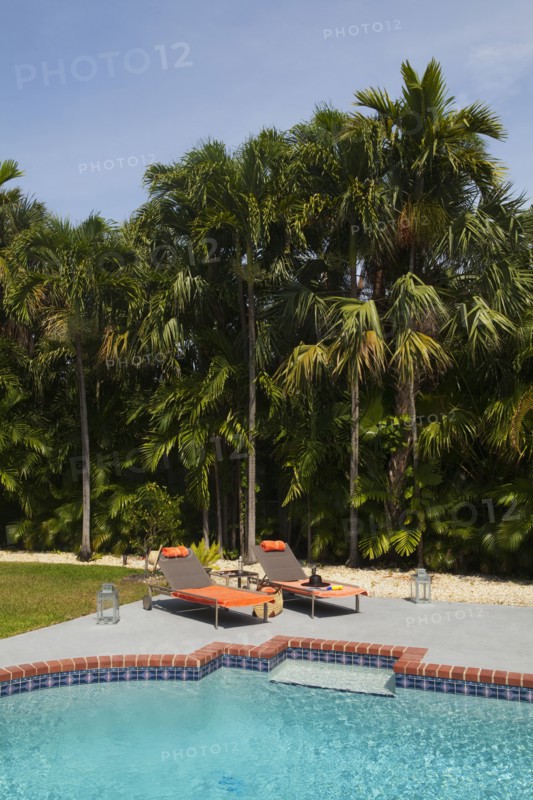 Deck chairs near swimming pool in backyard