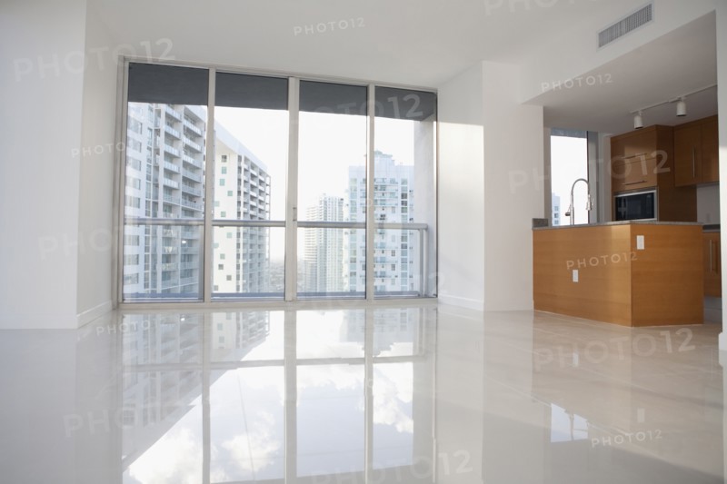 Windows and reflective floor in empty modern apartment