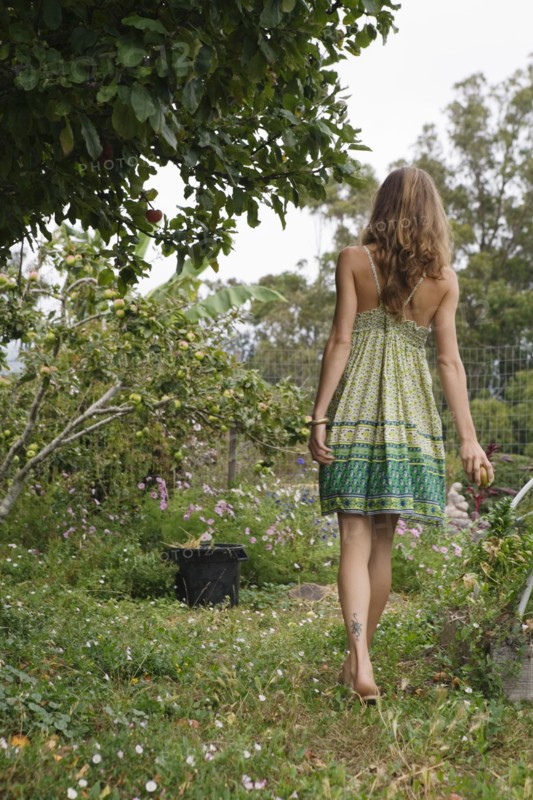 Mixed race woman talking next to fruit trees
