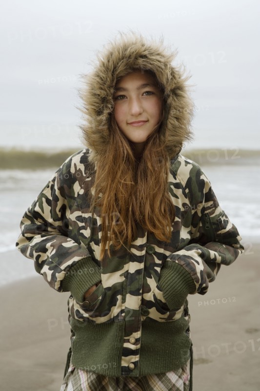 Mixed Race girl wearing jacket at beach
