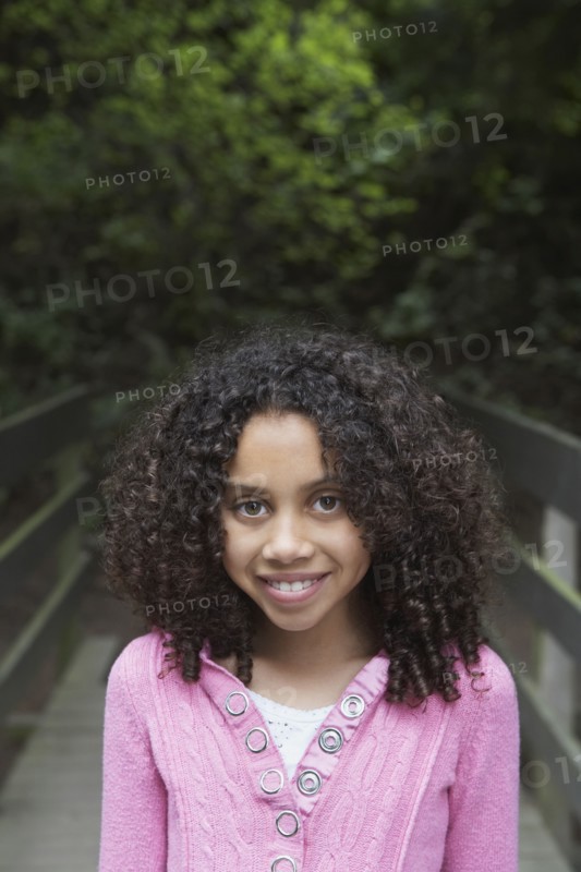 Mixed race girl crossing wooden bridge