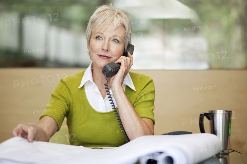 Smiling Caucasian architect talking on telephone