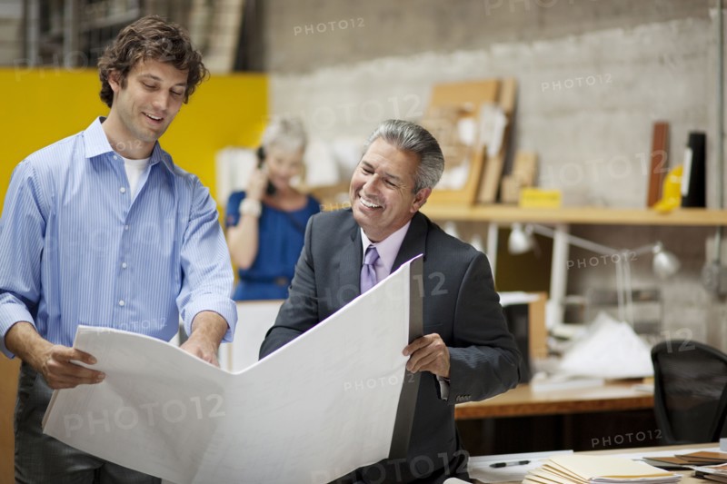 Architects reading blueprints in office