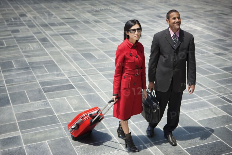 Business people with briefcase and rolling suitcase