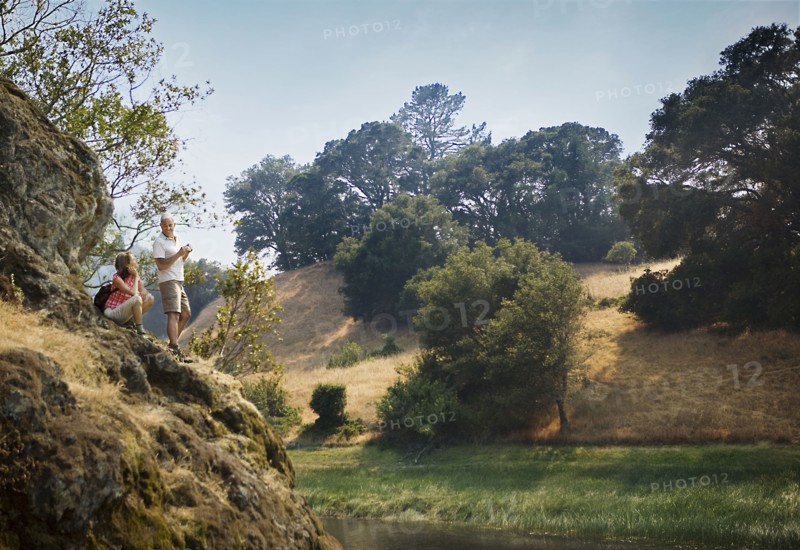 Couple standing on rocks admiring river
