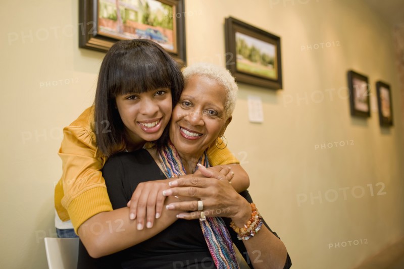 Grandmother and granddaughter hugging in gallery