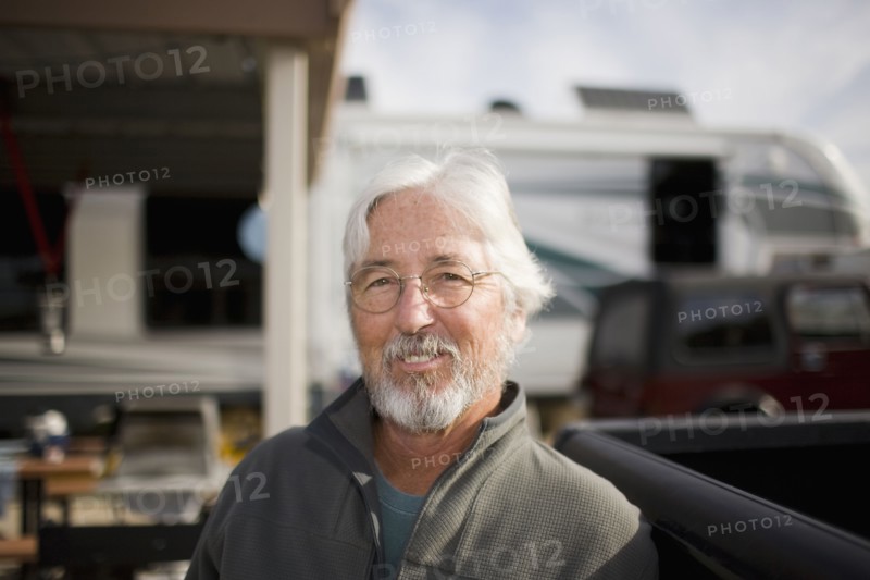 Senior Caucasian man sitting outside motor home