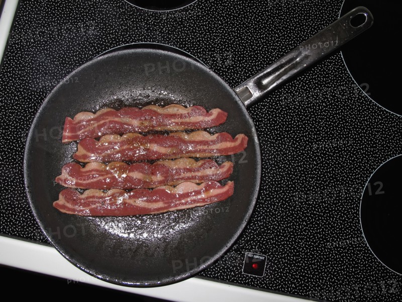 Bacon frying in pan on stove top