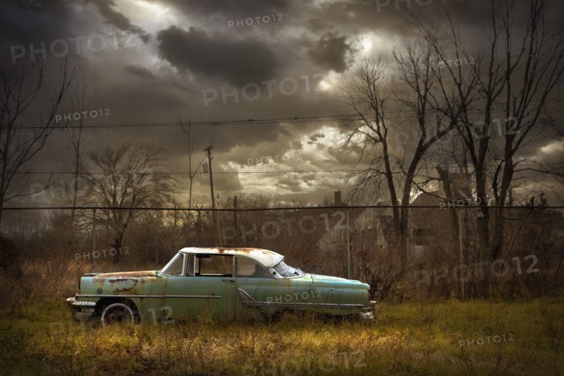 Rusted car in dilapidated urban field