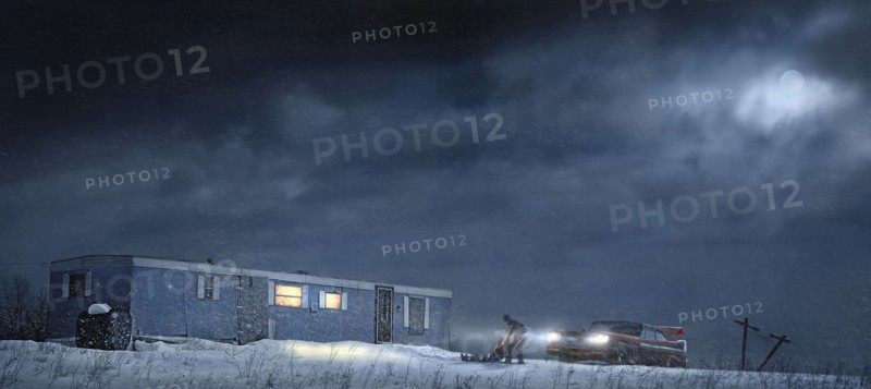 Man and car parked by illuminated trailer