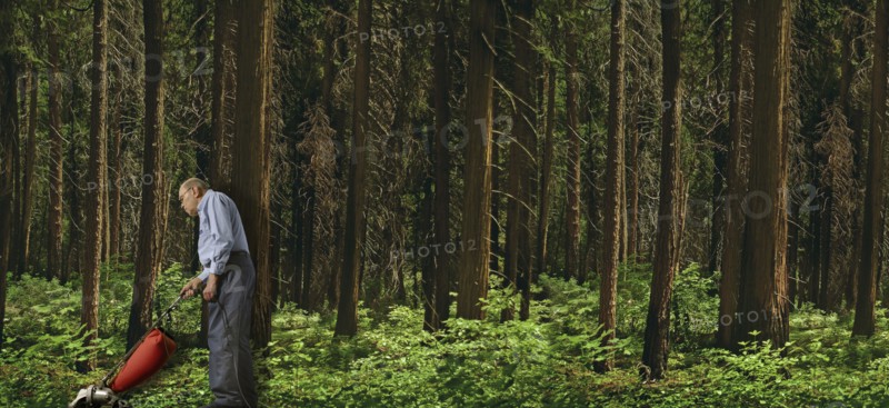 Caucasian man vacuuming forest floor