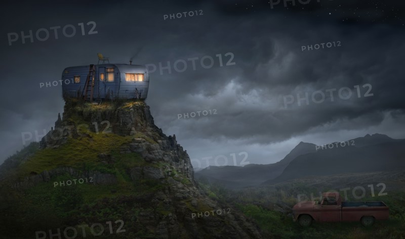 Illuminated trailer on rocky mountaintop