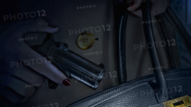 Woman putting pistol in purse