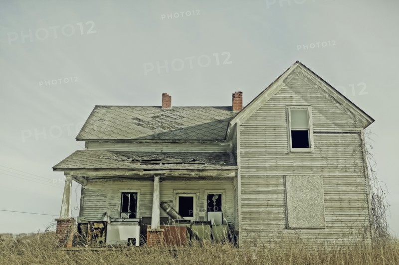 Dilapidated house in dry field