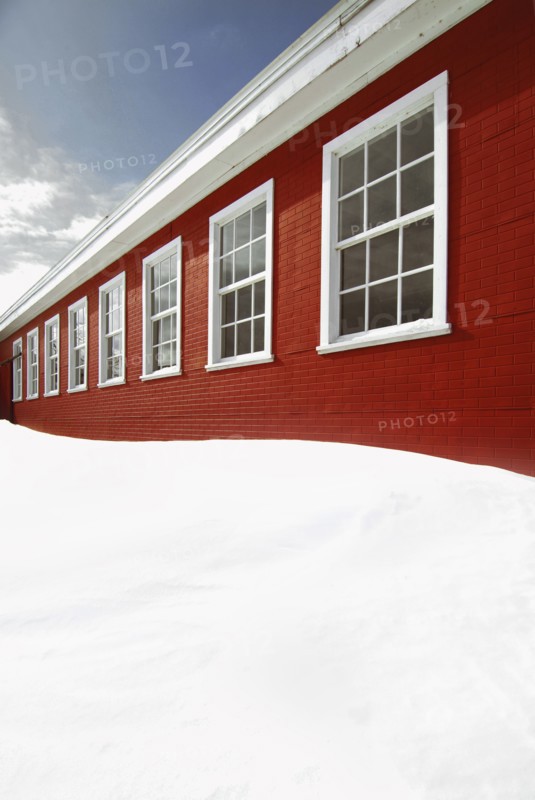 Snow piled up outside red building
