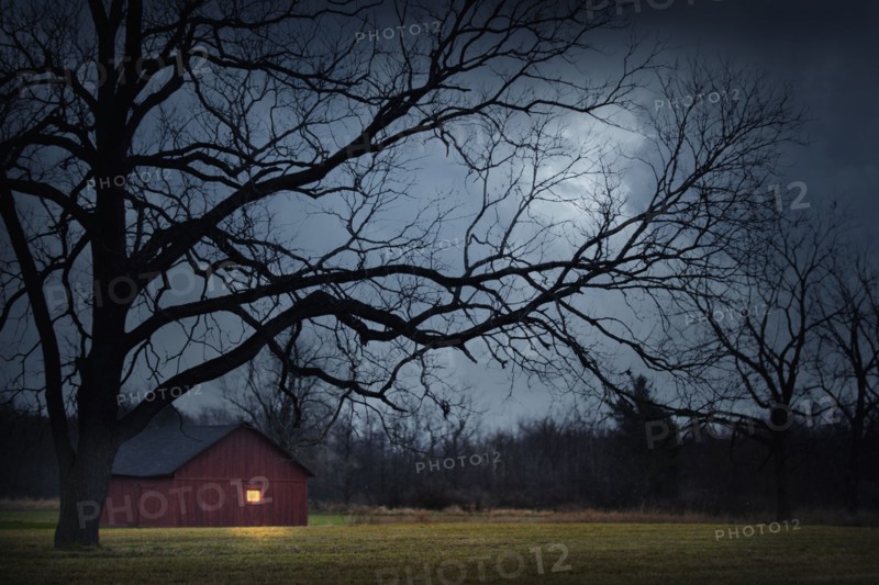 Illuminated barn in rural landscape