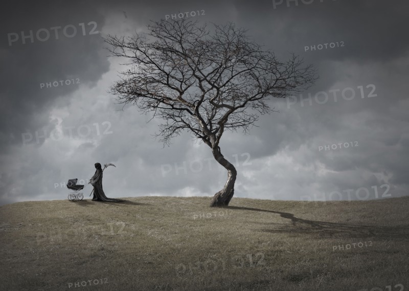 Man in black robes with baby carriage by dead tree