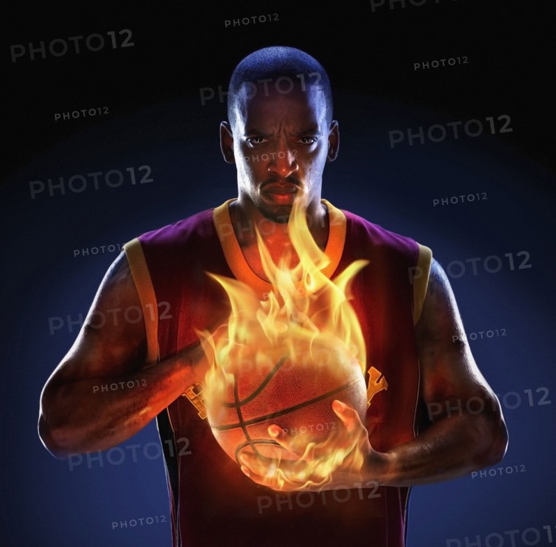 African American man holding flaming basketball