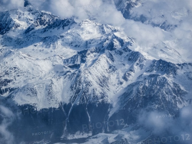 Clouds and snow covered mountains