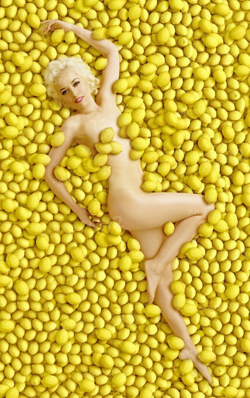 Caucasian woman laying in pile of lemons