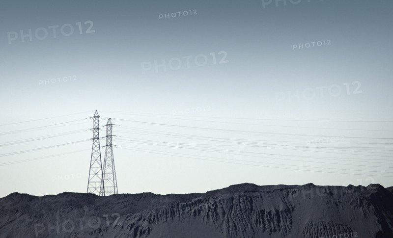 Silhouette of power lines over rocky landscape