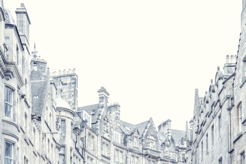 Low angle view of townhouse roofs and chimneys