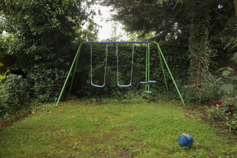 Empty swing set in backyard