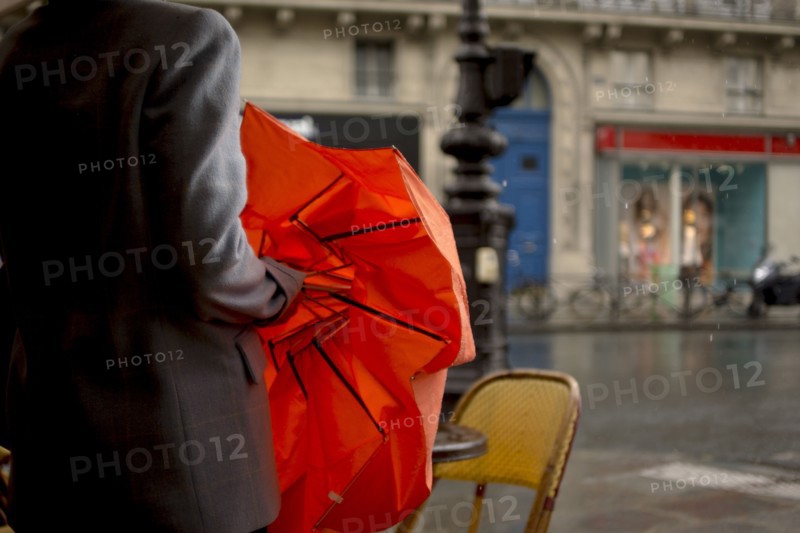 Close up of woman opening umbrella on rainy city street